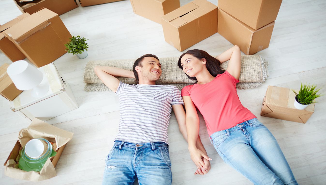 couple laying on floor surrounded by moving boxes