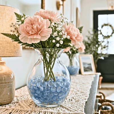 Glass vase with pink flowers and blue filler gems displayed with a lamp and photo frame - thumbnail number 5
