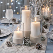 Lit candles in glass cylinders with natural white sand and pine cones - thumbnail number 5