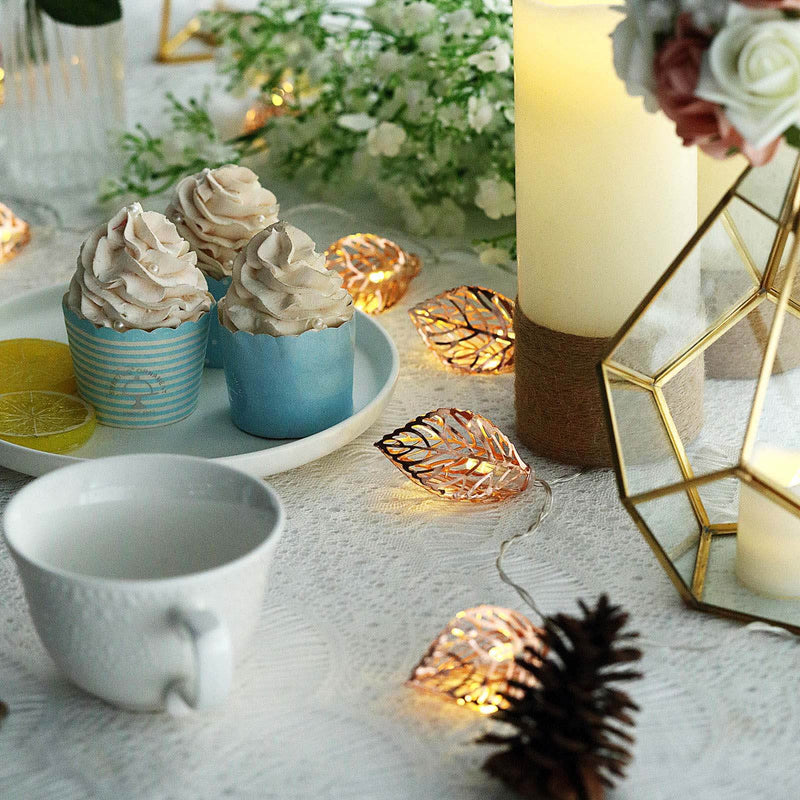 Decorative dessert setup with cupcakes, candles, and fairy lights on a table. - thumbnail number 1