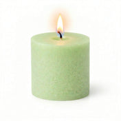 A lit green votive candle on white background - thumbnail number 4