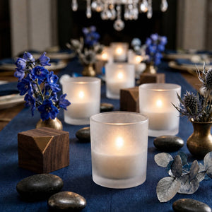Frosted glass votive candles on elegant blue floral dinner table centerpiece
