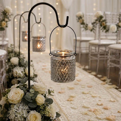 Patterned glass lanterns on hooks lining a wedding walkway with flower petals - thumbnail number 5