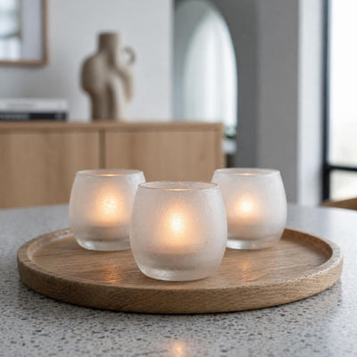 Three glowing frosted glass votive holders on a wooden tray in a bright minimalist interior - thumbnail number 8