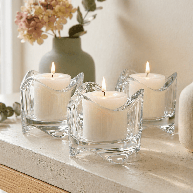 Three lit candles in clear glass holders on a stone surface with a blurred background - thumbnail number 9