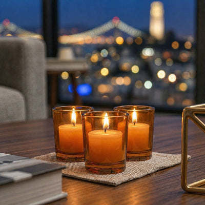 Amber glass votive candles glowing on table with city lights in background - thumbnail number 8