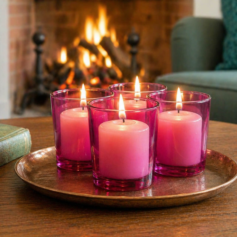 Four lit candles in pink glass holders on a copper tray with a fireplace in the background - thumbnail number 7