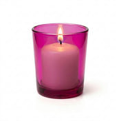 Lit white candle in a pink glass holder on a solid white background - thumbnail number 3