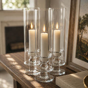 White vigil candles in clear glass holders on wooden table with warm glow - thumbnail number 7