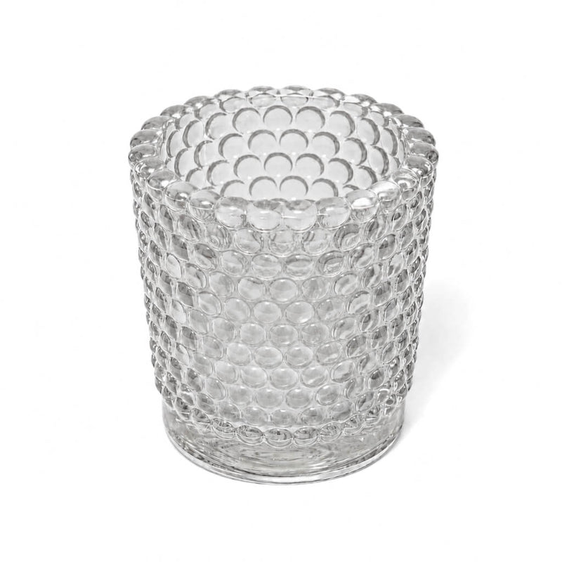 An empty clear hobnail glass votive holder isolated on a solid white background - thumbnail number 1