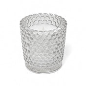 An unlit white candle inside a clear hobnail glass votive holder on a solid white background - thumbnail number 2