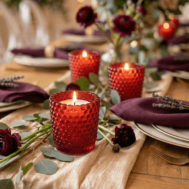 Red hobnail votive holders with candles on rustic decorated dinner table - thumbnail number 6