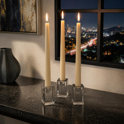 Elegant ivory taper candles in glass holders on dark countertop - thumbnail number 6