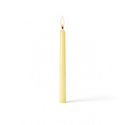 Ivory lit taper candle standing on white background - thumbnail number 2