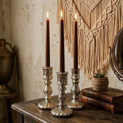 Three lit brown taper candles in silver holders on rustic wooden table - thumbnail number 7
