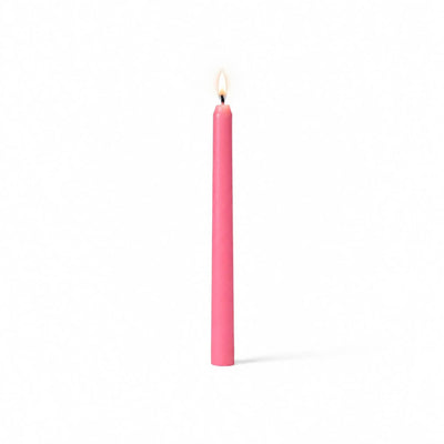 Single pink taper candle with flame on white backdrop - thumbnail number 2