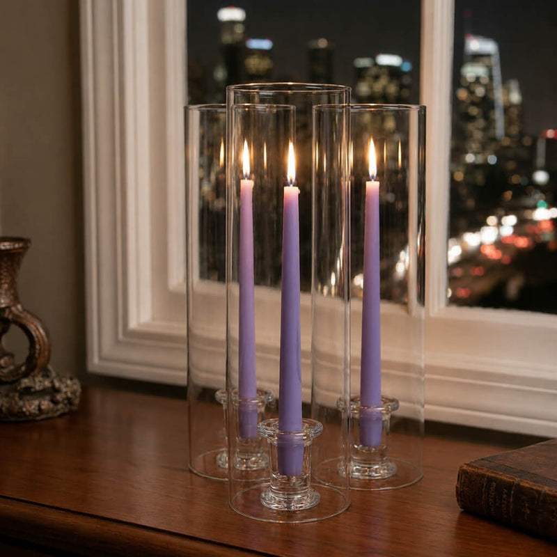 Lavender candles in clear glass holders on table near nighttime window - thumbnail number 6