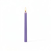 Single lavender taper candle glowing on white surface - thumbnail number 2