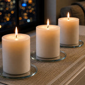 Lit white pillar candles on a Round Coaster 4" display set against a city night backdrop - thumbnail number 10