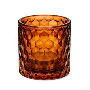 Amber cut-glass candle holder with geometric pattern and a tealight inside.