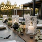 Outdoor dining table with lit glass candle holders, succulents, and string lights bokeh - thumbnail number 5