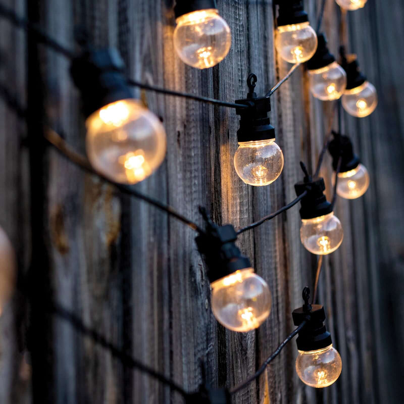 String lights hanging on a wooden fence at dusk, creating a warm ambiance. - thumbnail number 1