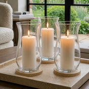 A clean and intentional living room display featuring a trio of clear 10.5 Hurricane Vases - thumbnail number 7