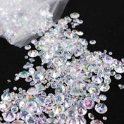 Mixed clear rhinestones scattered on a black surface. - thumbnail number 1
