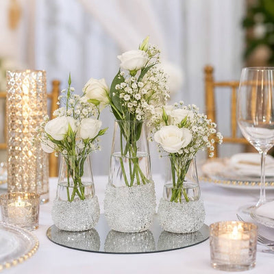 Three glass vases filled with white roses and glitter on a table - thumbnail number 8