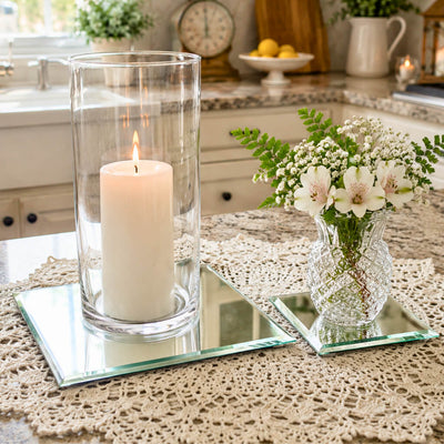 A lit candle in a glass holder and a small flower vase on mirrored coasters on a kitchen counter - thumbnail number 8