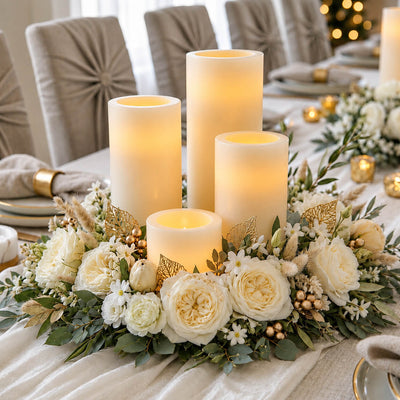 A floral centerpiece with white roses and ivory flameless LED pillar candles on a table - thumbnail number 6