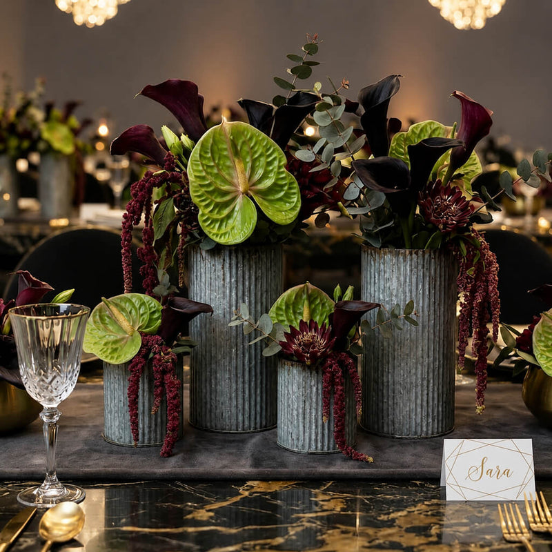 Dark floral arrangements in corrugated metal vases on an elegant table setting - thumbnail number 4