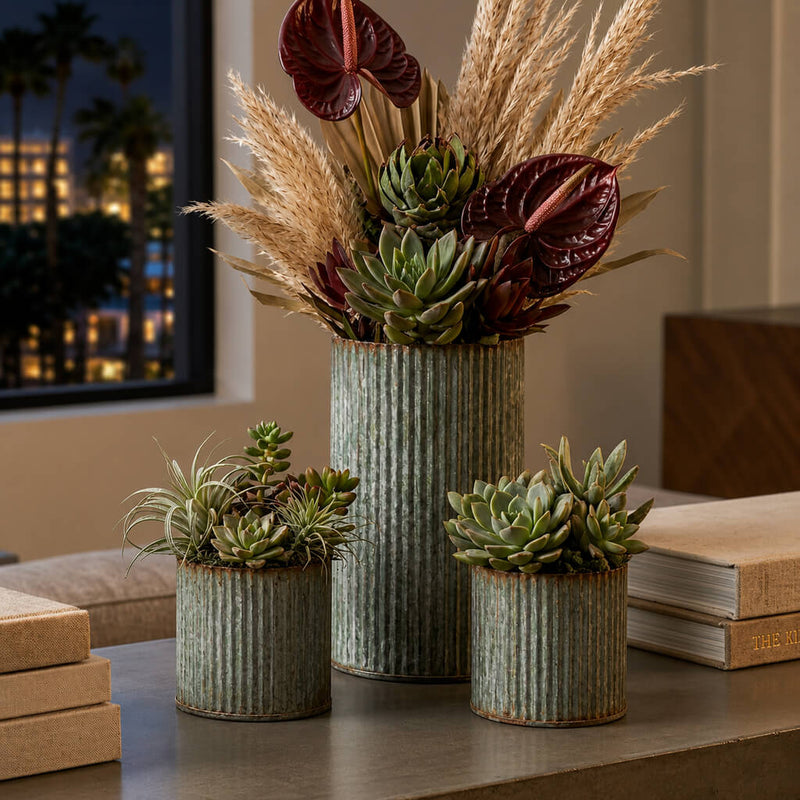 Succulents and dried foliage in corrugated metal vases on a table - thumbnail number 7