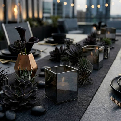 Lit mirrored candle holders on modern table with succulent arrangements - thumbnail number 6