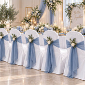 White banquet chair covers with blue sashes and floral decor at a wedding - thumbnail number 2