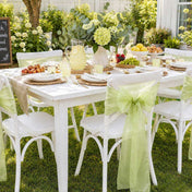 White chairs with sage organza sashes at an outdoor table - thumbnail number 8