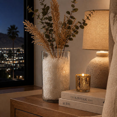 Glass vase filled with white confetti and dried branches next to a lamp, books, and a lit candle - thumbnail number 8
