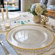 Glass charger plate with gold beaded rim on a table with candles and flowers - thumbnail number 6