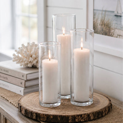 Three lit white candles in glass cylinder vases on a wood slice tray - thumbnail number 8
