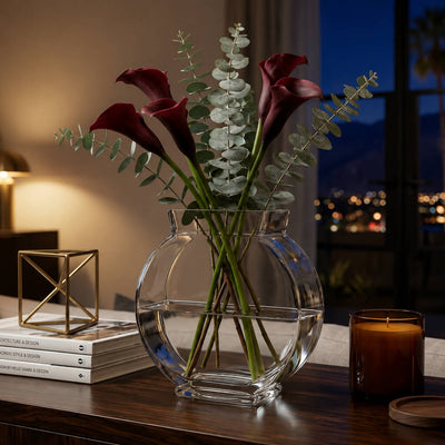 Clear circular vase with dark purple calla lilies and eucalyptus on a dark wooden table - thumbnail number 8