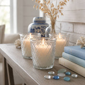 A trio of Tipper Vase & Candle Holders casting a warm light in a bright, beach-inspired room - thumbnail number 8
