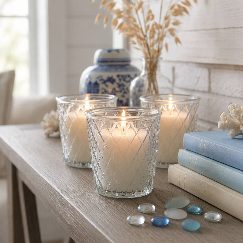 A trio of Tipper Vase & Candle Holders casting a warm light in a bright, beach-inspired room - thumbnail number 8