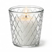 Close-up of a lit candle glowing through a patterned clear glass Tipper Vase & Candle Holder - thumbnail number 3