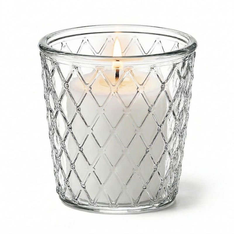 Close-up of a lit candle glowing through a patterned clear glass Tipper Vase & Candle Holder - thumbnail number 3