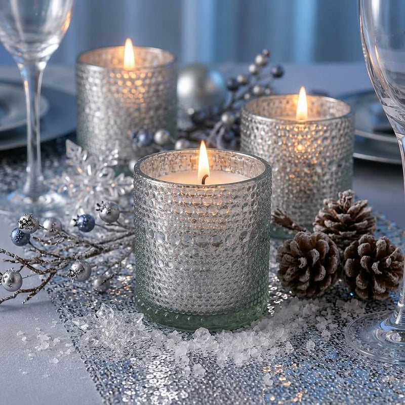 Pearly silver candle holders with winter decor and glowing candles on a festive table - thumbnail number 3