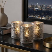 Set of glowing pearly silver candle holders on a modern table with city view - thumbnail number 7