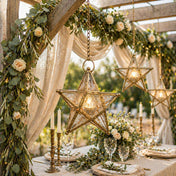 Decorative table setting with star-shaped lanterns, greenery, and candles in an outdoor setting. - thumbnail number 5