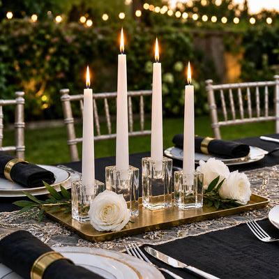 Four lit white taper candles in glass holders on a gold tray at an outdoor table - thumbnail number 8