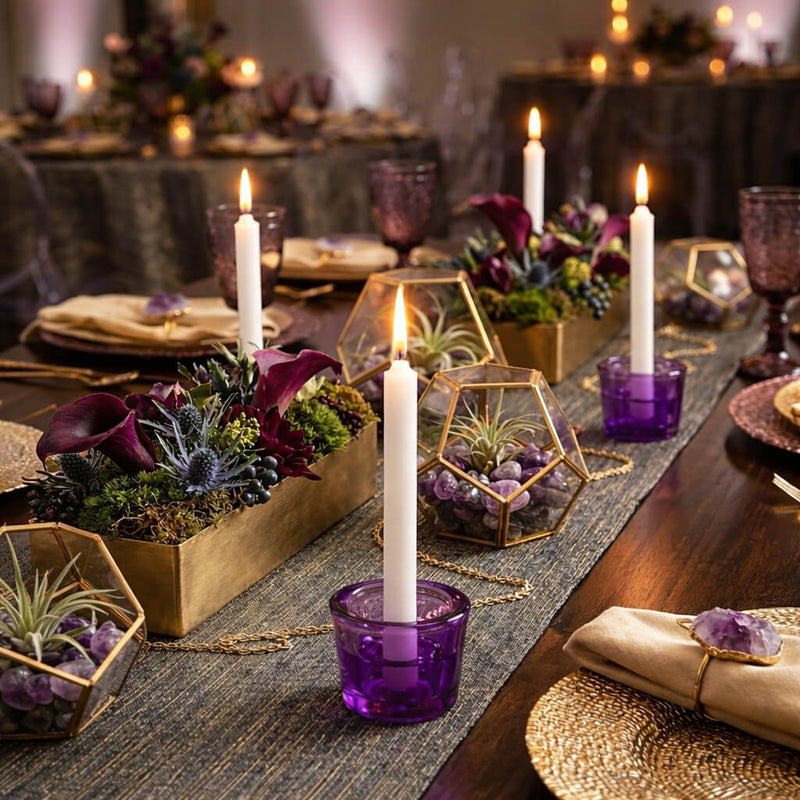 Lit white taper candles in purple glass holders on a decorated event table - thumbnail number 7