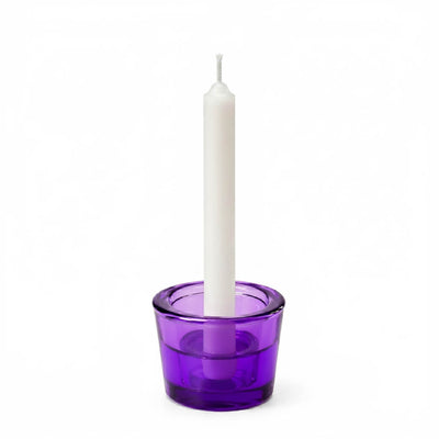 White taper candle in a purple glass holder on a white background - thumbnail number 4